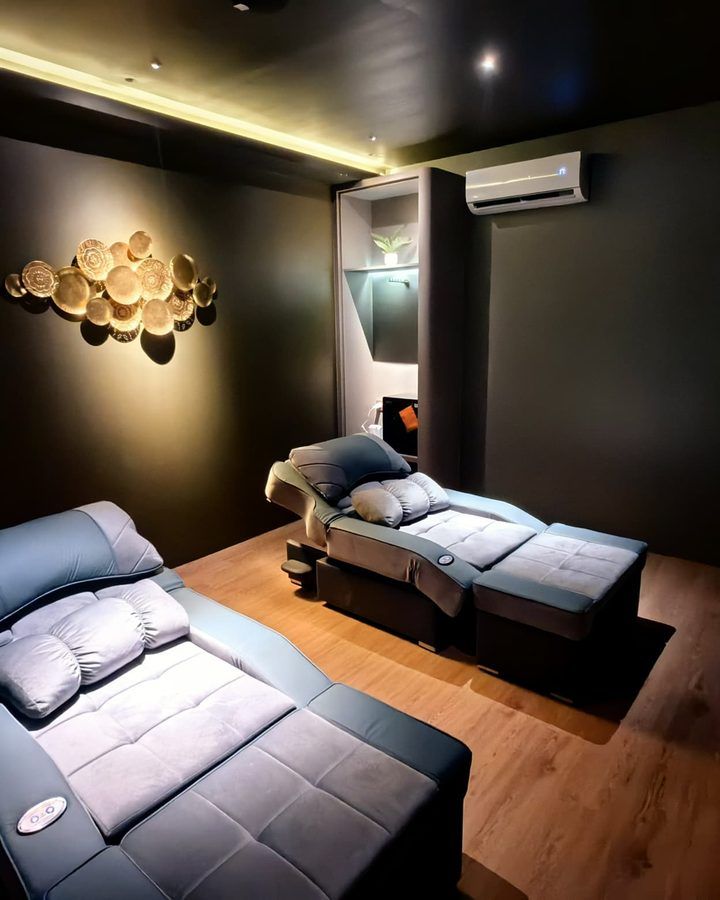 A private treatment room at Rexury with two cushioned massage beds and warm gold lighting