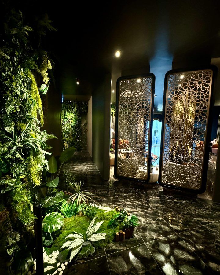 Marble walkway lined with a living green wall and moss garden inside Rexury Wellness Centre