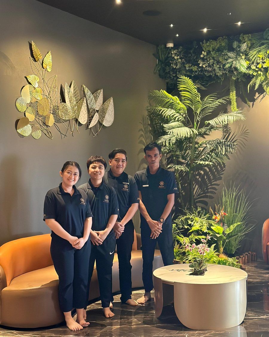 Four Rexury therapists in branded uniform standing in the lounge