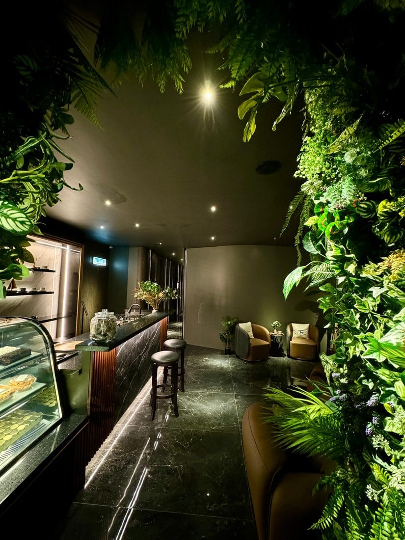 The 5-star lounge at Rexury with a living green wall, black marble floor and warm gold uplighting